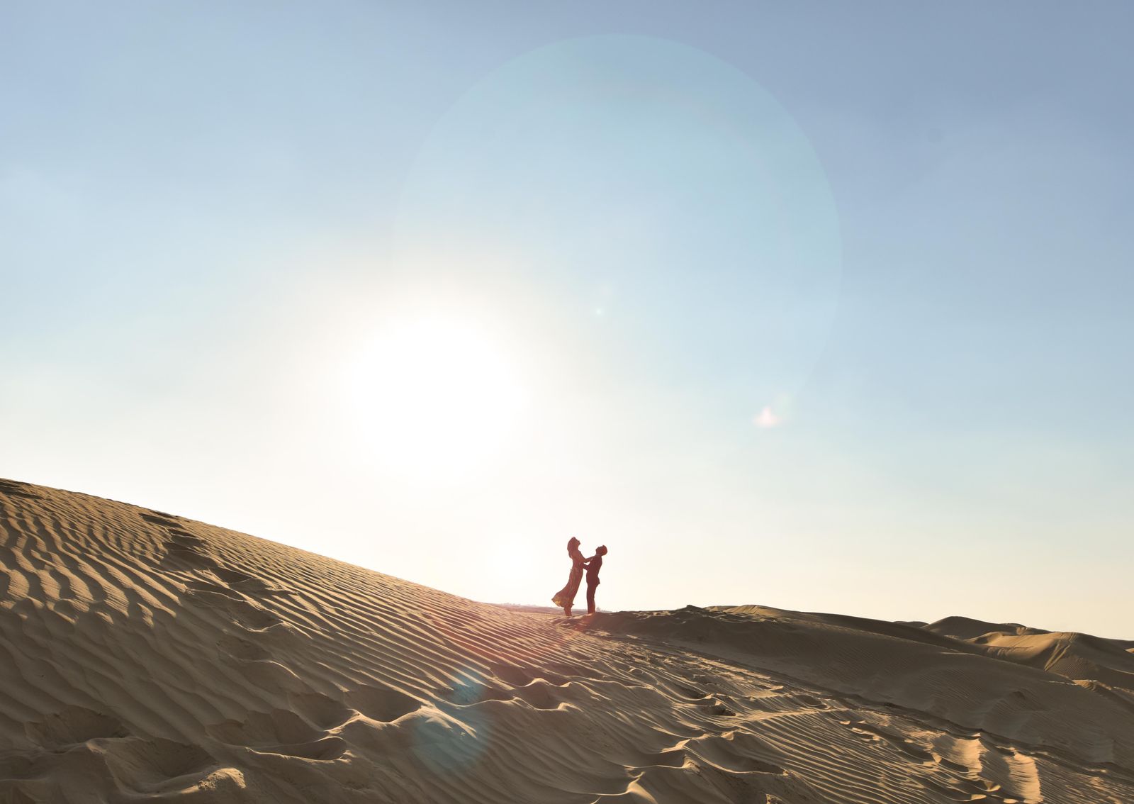 Couple enjoying a romantic Egyptian desert sunset