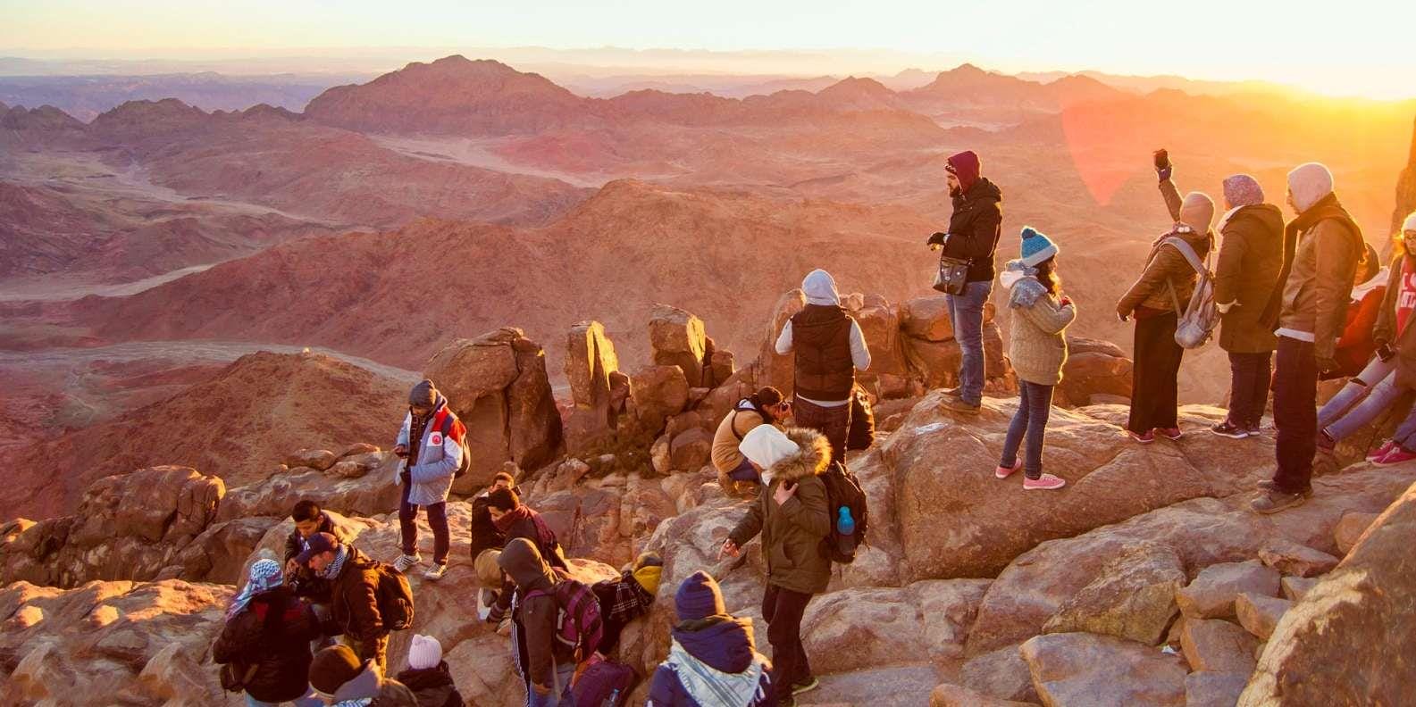 Travelers watching sunrise from Mount Sinai