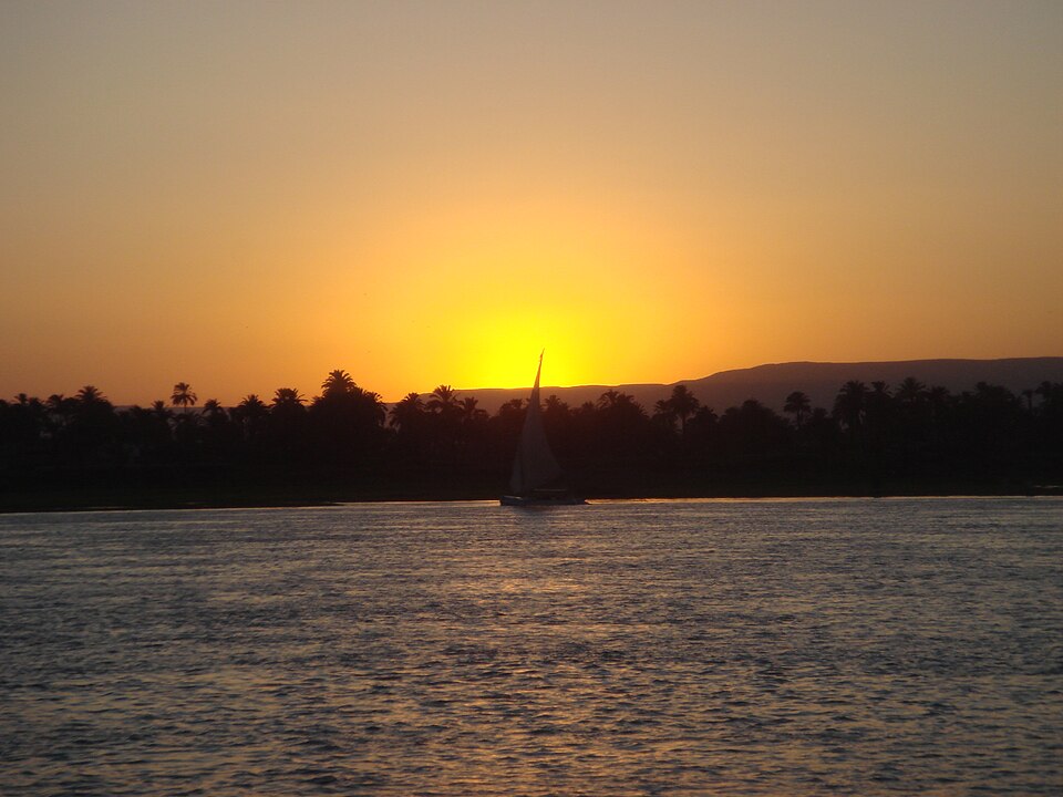 A traditional felucca sailing on the Nile at sunset