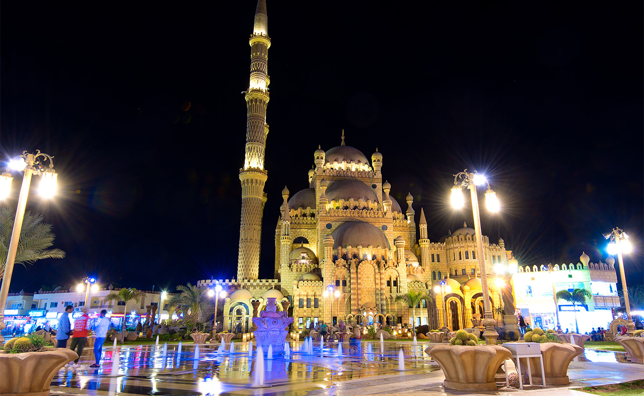 Al Sahaba Mosque illuminated above the lively Old Market